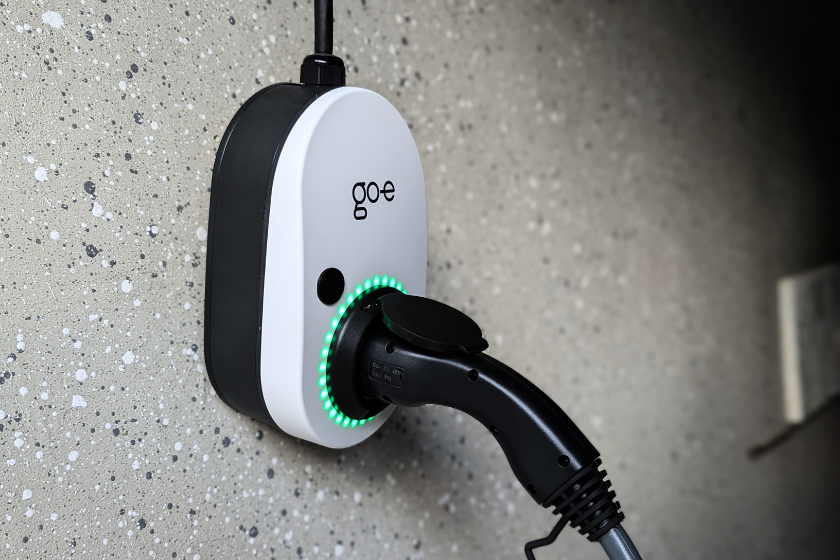 Der go-e Charger Gemini flex leuchtet grün, was einen abgeschlossenen Ladevorgang anzeigt. 