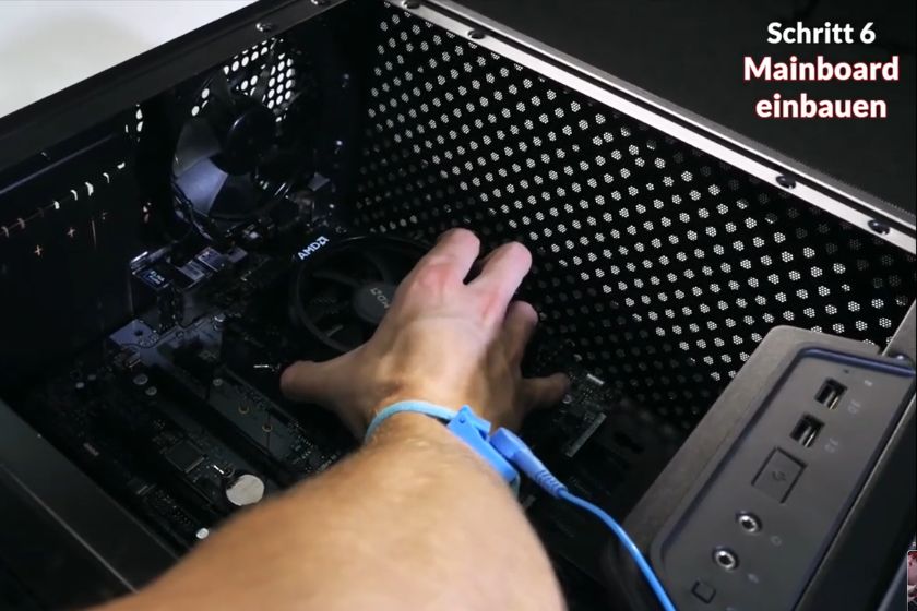 Nahaufnahme: Eine Person setzt Mainboard in ein PC-Gehäuse ein