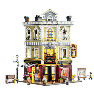 Abbildung des Klemmbausteinsets "Antiquitätenladen" von Lumibricks. Konstruktions-Modell eines historischen Eckhauses mit antikem Ladengeschäft auf Straßenebene und Minifiguren.