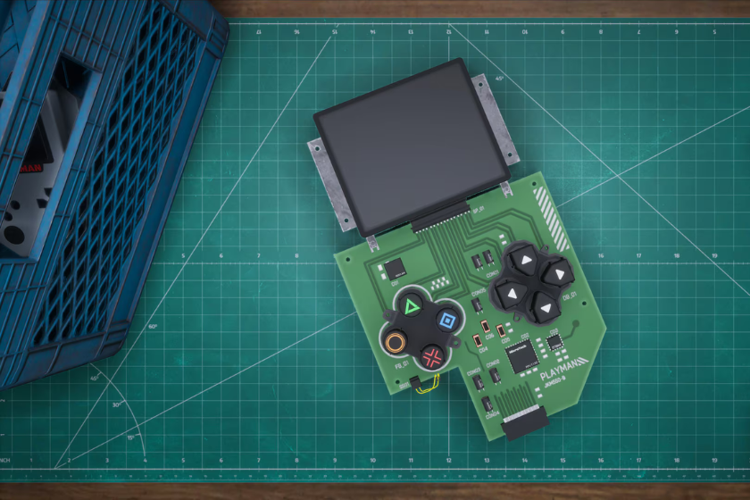 Eine geöffnete elektronische Platine mit Display und Spielcontroller-Tasten liegt auf einer grünen Schneidematte. Links steht ein blauer Werkzeugkasten.