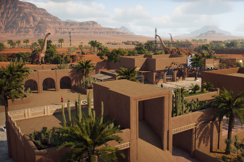 Wüstenlandschaft mit einem aufgebauten prähistorischen Zoo, Gehegen und Dinosauriern im Hintergrund in Prehistoric Kingdom