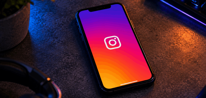 Instagram-App auf einem Smartphone neben Gaming-Tastatur und Maus.