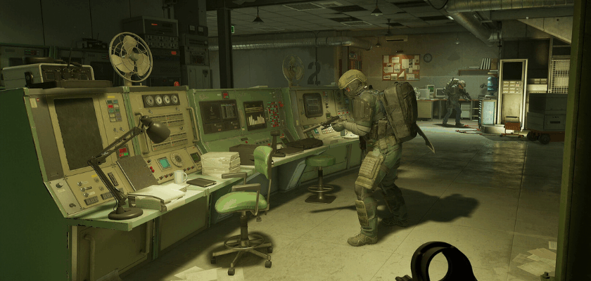 Screenshot aus PUBG: Black Budget: Ein bewaffneter Soldat durchsucht einen verlassenen Kontrollraum voller Computer und Technik. Im Hintergrund sind weitere Einsatzkräfte zu sehen. Die düstere Atmosphäre und die heruntergekommene Forschungseinrichtung vermitteln den Eindruck eines gefährlichen Extraction-Shooter-Einsatzes.