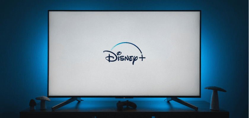 Fernseher mit Disney+-Logo auf dem Bildschirm in einem abgedunkelten Wohnzimmer.