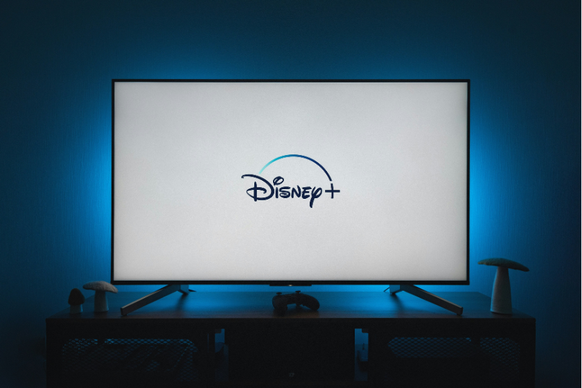 Fernseher mit Disney+-Logo auf dem Bildschirm in einem abgedunkelten Wohnzimmer.