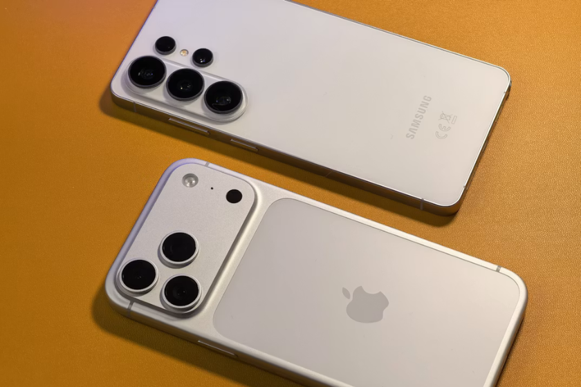 Ein Apple- und ein Samsung-Smartphone liegen nebeneinander auf einem orangenen Hintergrund.