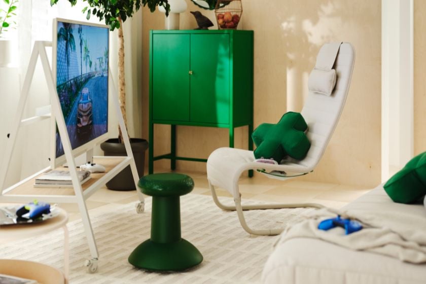 Gaming-Wohnzimmer mit Möbeln aus der IKEA YXSTABY Kollektion, darunter TV-Ständer, Loungesessel, grüner Thumbstick-Hocker und D-Pad-Kissen.