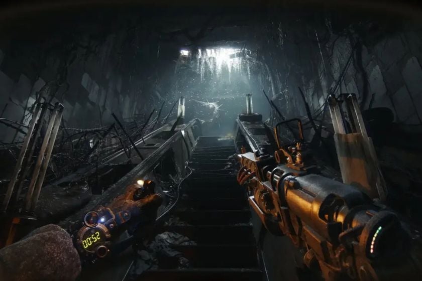 Gameplay-Szene aus METRO 2039 mit einer Waffe in der Hand in einem zerstörten, düsteren Metro-Tunnel.