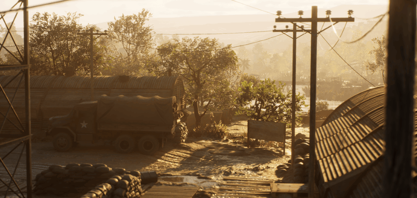 Spielszene aus Hell Let Loose: Vietnam mit einem Militärstützpunkt, Sandsäcken und einem Armeelastwagen in der vietnamesischen Landschaft.
