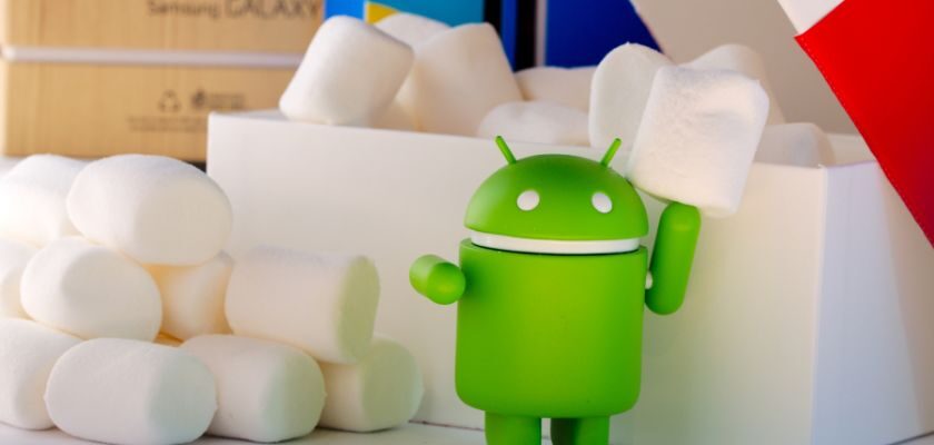 Grüne Android-Figur vor einer weißen Box mit Marshmallows im Hintergrund.