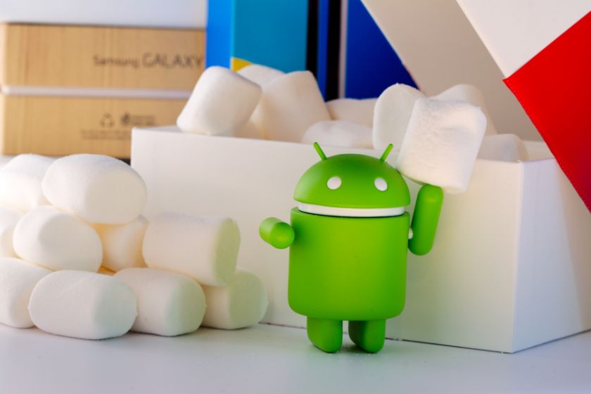 Grüne Android-Figur vor einer weißen Box mit Marshmallows im Hintergrund.