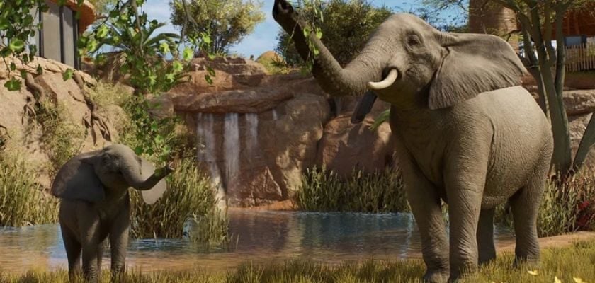 Afrikanischer Elefant mit Jungtier in einem begrünten Gehege mit Wasserstelle in Planet Zoo 2