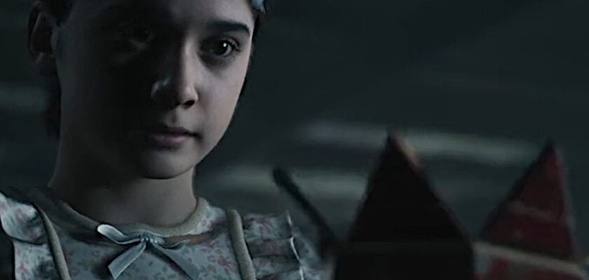 Junges Mädchen in einem geblümten Kleid blickt in einer düsteren Szene aus The Conjuring: Stillschweigen auf eine geheimnisvolle Box.