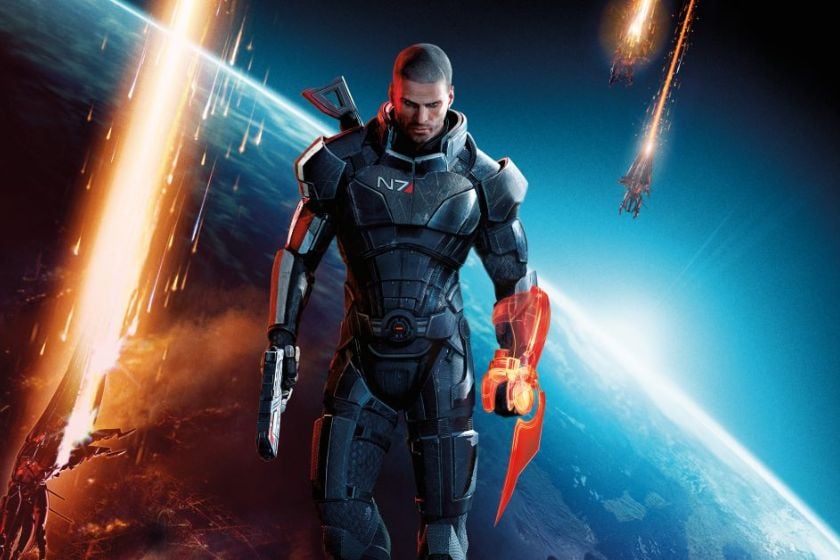 Commander Shepard aus Mass Effect 3 steht in seiner N7-Rüstung mit einer Waffe vor einem Planeten, während im Hintergrund Raumschiffe abstürzen.