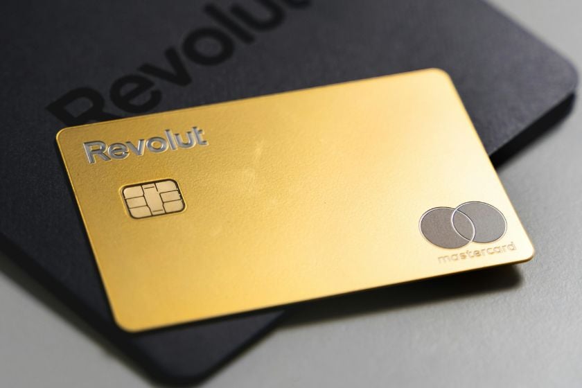 Goldene Revolut-Mastercard mit Chip auf einer schwarzen Kartenverpackung mit Revolut-Logo.
